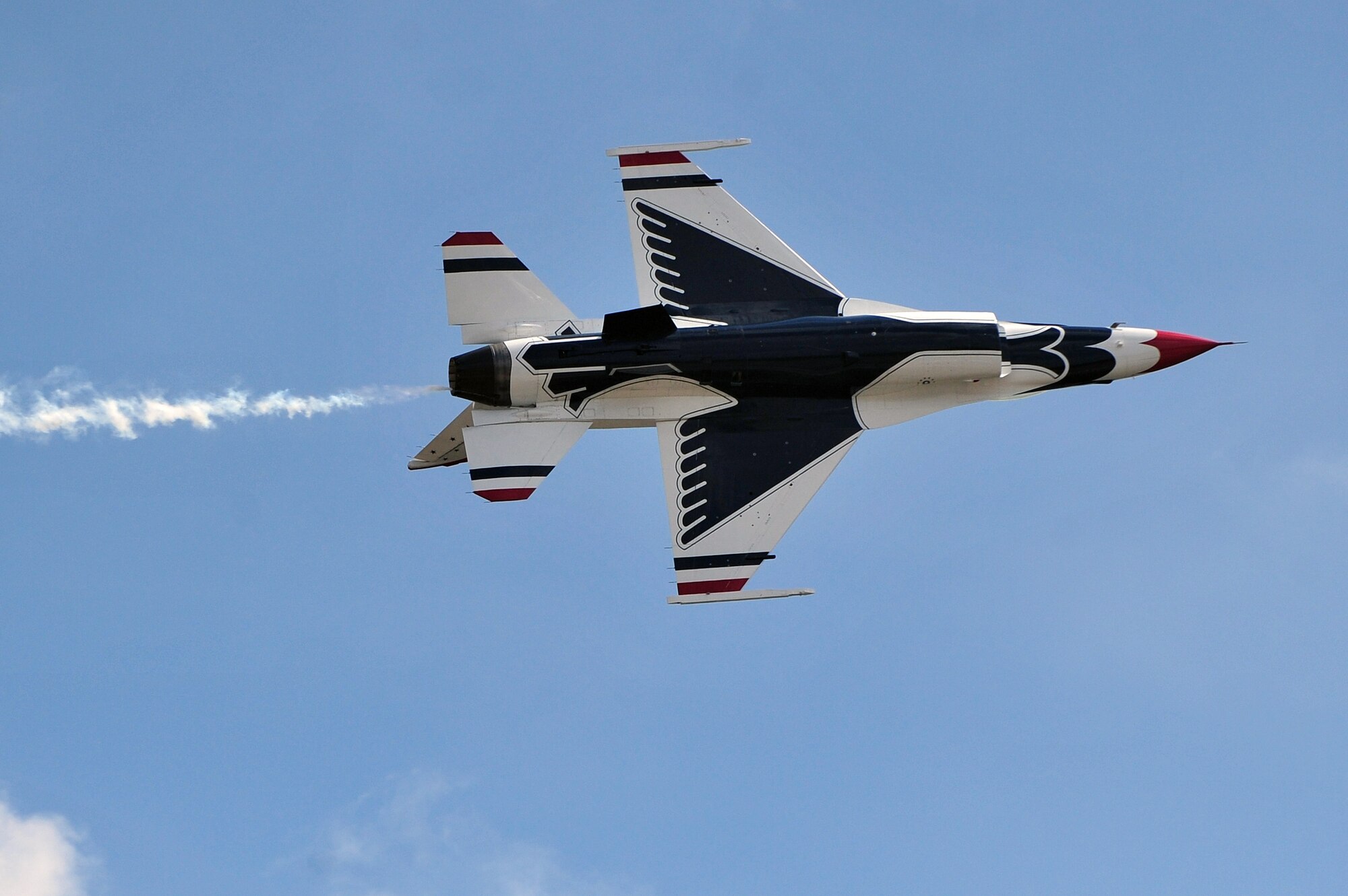 A member of the U.S. Air Force Thunderbirds aerial demonstration team executes a knife edge pass as part of the 2015 Wings Over Wayne Airshow and Open House, May 16, 2015, at Seymour Johnson Air Force Base, North Carolina. The Thunderbirds aim to strengthen morale and support community relations by performing during airshows and other events. (U.S. Air Force photo/Senior Airman John Nieves Camacho)