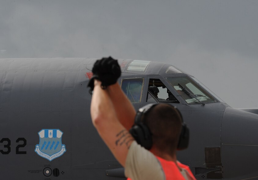 A 2nd Bomb Wing crew chief communicates with a B-52H Stratofortress pilot while preparing to marshal an aircraft out for takeoff in support of a 35-hour, 14,000-mile nonstop sortie in support of Exercise Eager Lion 2015 at Barksdale Air Force Base, La., May 17, 2015. Eager Lion is one of USCENTCOM's premier exercises, and consists of a series of simulated scenarios to facilitate a coordinated, partnered military response to both conventional and unconventional threats. Participating in the exercise provides Air Force Global Strike Command aircrews valuable interoperability training with multinational forces outside the United States. (U.S. Air Force photo/Staff Sgt. Jason McCasland)