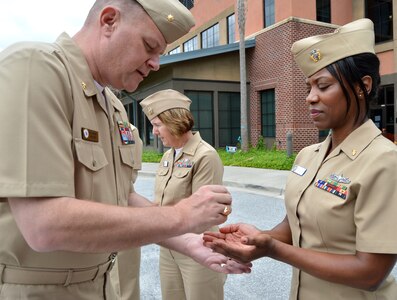 Lt. Cdr. Wes Modder, Naval Nuclear Power Training Command chaplain, blesses
the hands of Lt. Teresa Taylor, a clinical nurse at Naval Health Clinic
Charleston, during a "Blessing of the Hands" ceremony as part of National
Nurses Week May 6-13. The "Blessing of the Hands"  ceremony is a hospital
tradition practiced around the world during Nurses Week to honor nurses who
use their hands in many ways to bring healing to patients. (Navy photo by
Kris Patterson)
