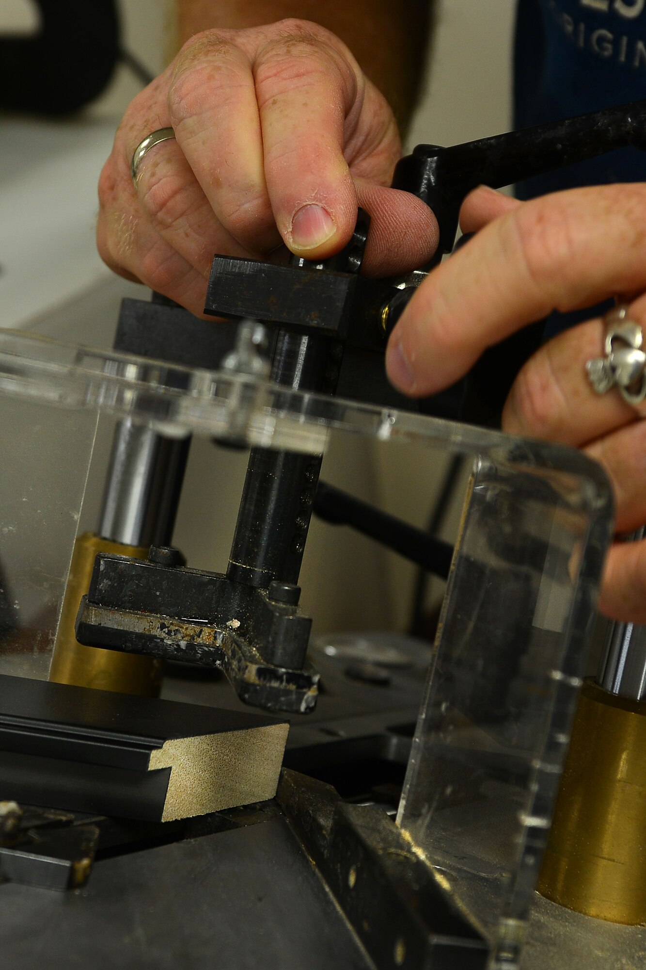 Mark Winslow, 733rd Mission Support Division Morale, Welfare and Recreation frame shop technician, uses a pinner to join two parts of a frame together at Fort Eustis, Va., May 12, 2015. The pinner pierces small needles into the center of the frame pieces joining them together with no visible obstruction to the outside of the frame. (U.S. Air Force photo by Staff Sgt. Natasha Stannard/Released)