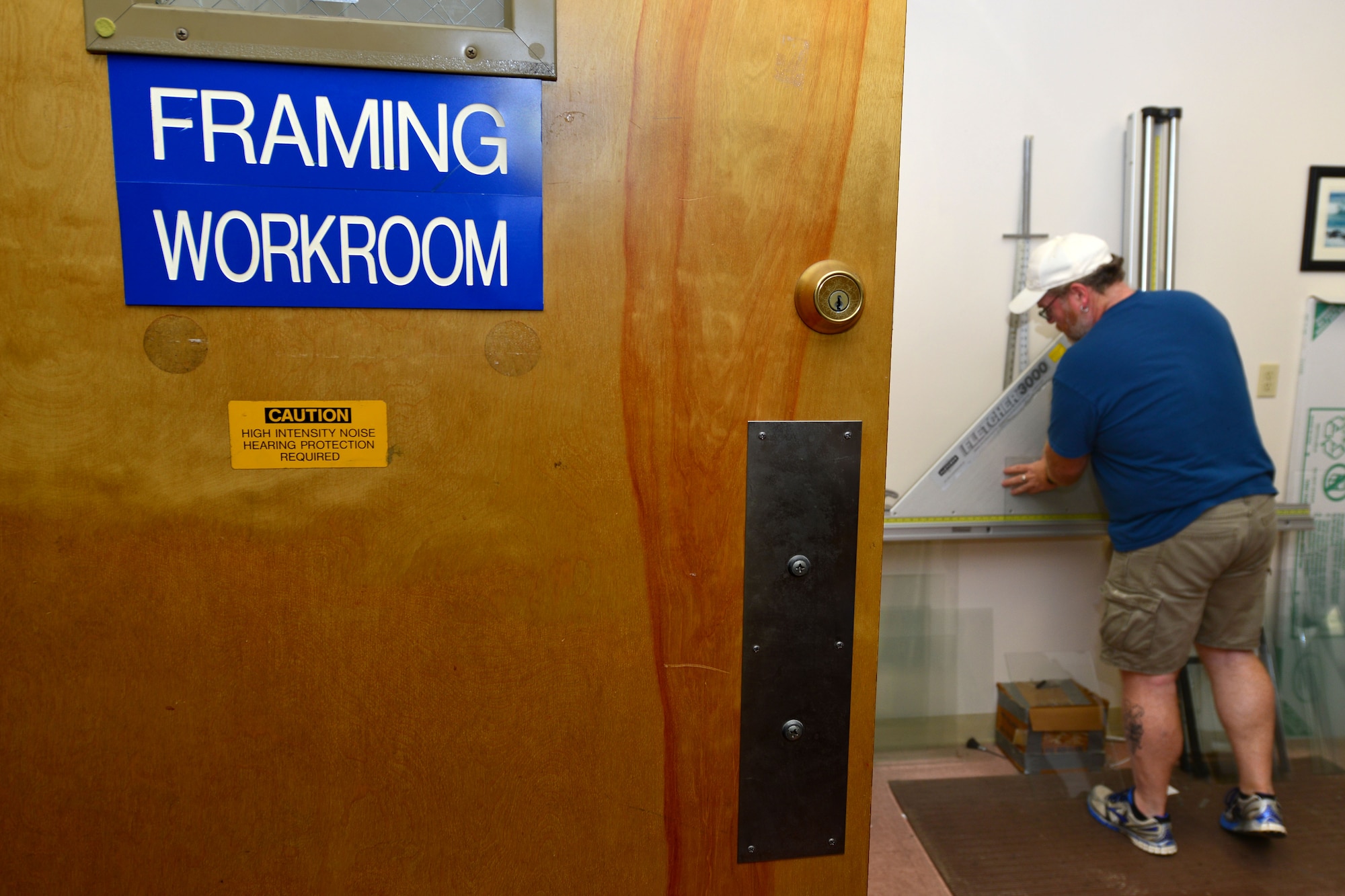 Mark Winslow, 733rd Mission Support Division Morale, Welfare and Recreation frame shop technician, cuts glass for a frame at Fort Eustis, Va., May 12, 2015. The frame shop provides picture framing, matte cutting, glass replacement, poster mounting, canvas and needlework stretching and frame supplies. (U.S. Air Force photo by Staff Sgt. Natasha Stannard/Released)