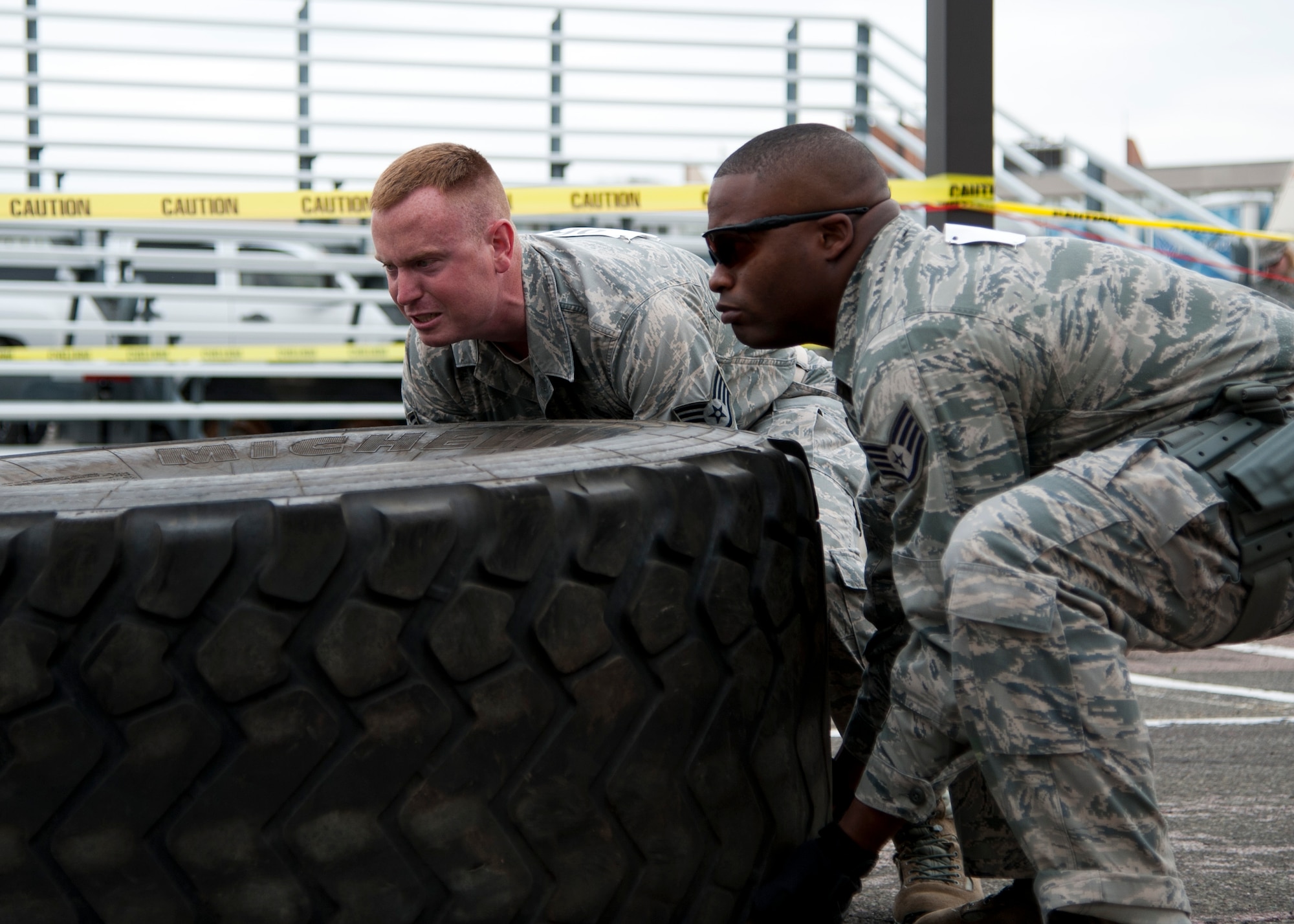 PETERSON AIR FORCE BASE, Colo. – Staff Sgts. Anthony Brodie and Warren Smith, 21st Security Forces Squadron, team up for the shoot house challenge, part of Police Week at the 21st SFS training center, May 14, 2014. The shoot house challenge consisted of several obstacles including tire flipping, physical training, door breaching, target shooting with weapons equipped with lasers, close quarters combat and a dummy drag. (U.S. Air Force photo by Senior Airman Tiffany DeNault)