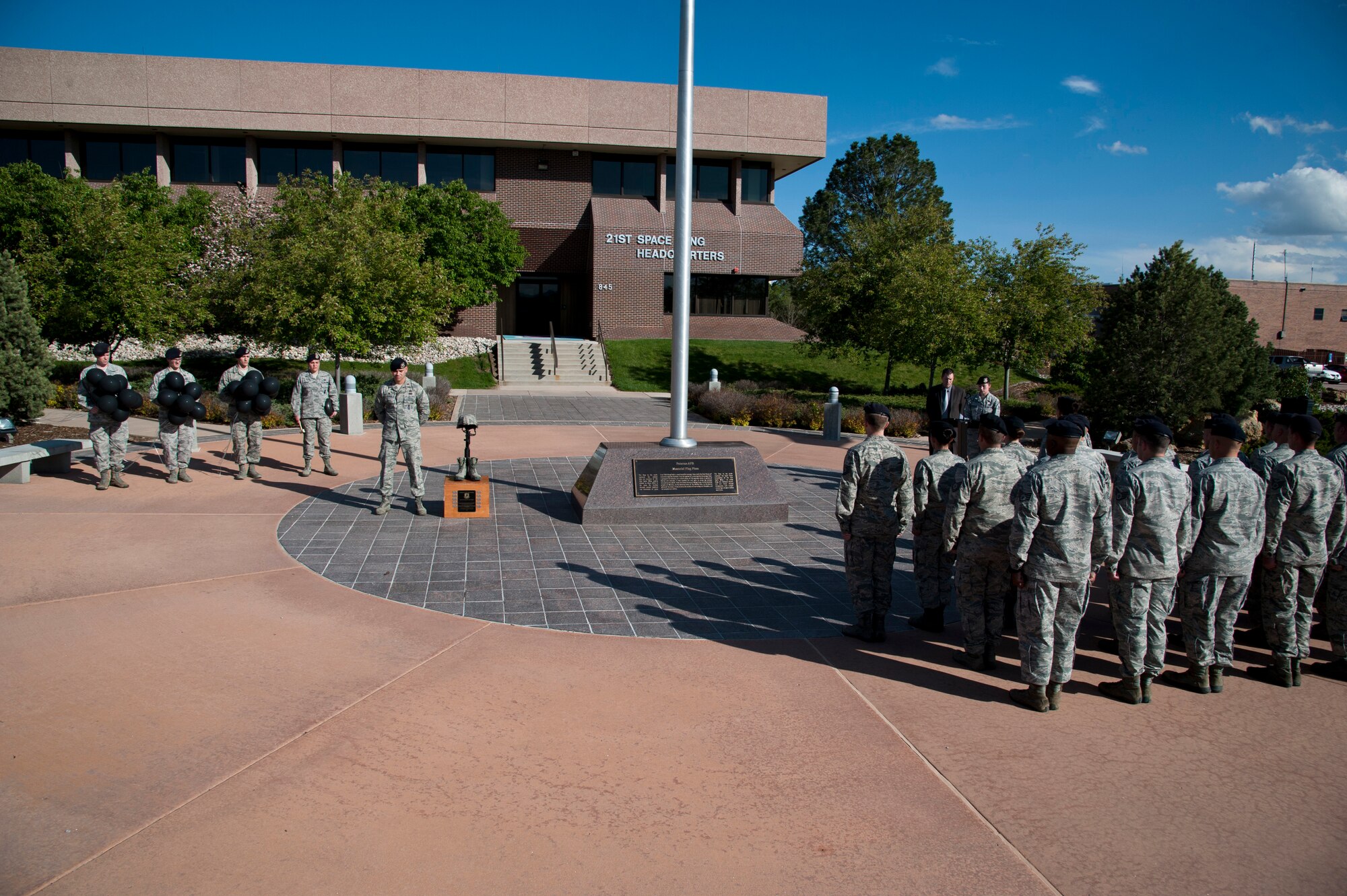 PETERSON AIR FORCE BASE, Colo. – Members of the 21st Security Forces Squadron participate in the closing ceremony at the fallen defenders vigil May 12, 2015. The Airmen took turns standing guard by the American flag and a display honoring the fallen defenders at the 21st Space Wing Headquarters building throughout the 12-hour remembrance. The vigil was one of several events recognizing Police Week, including a shoot house challenge, K9 military working dog demonstration, and a law enforcement memorial at Colorado Springs Memorial Park. (U.S. Air Force photo by Senior Airman Tiffany DeNault)