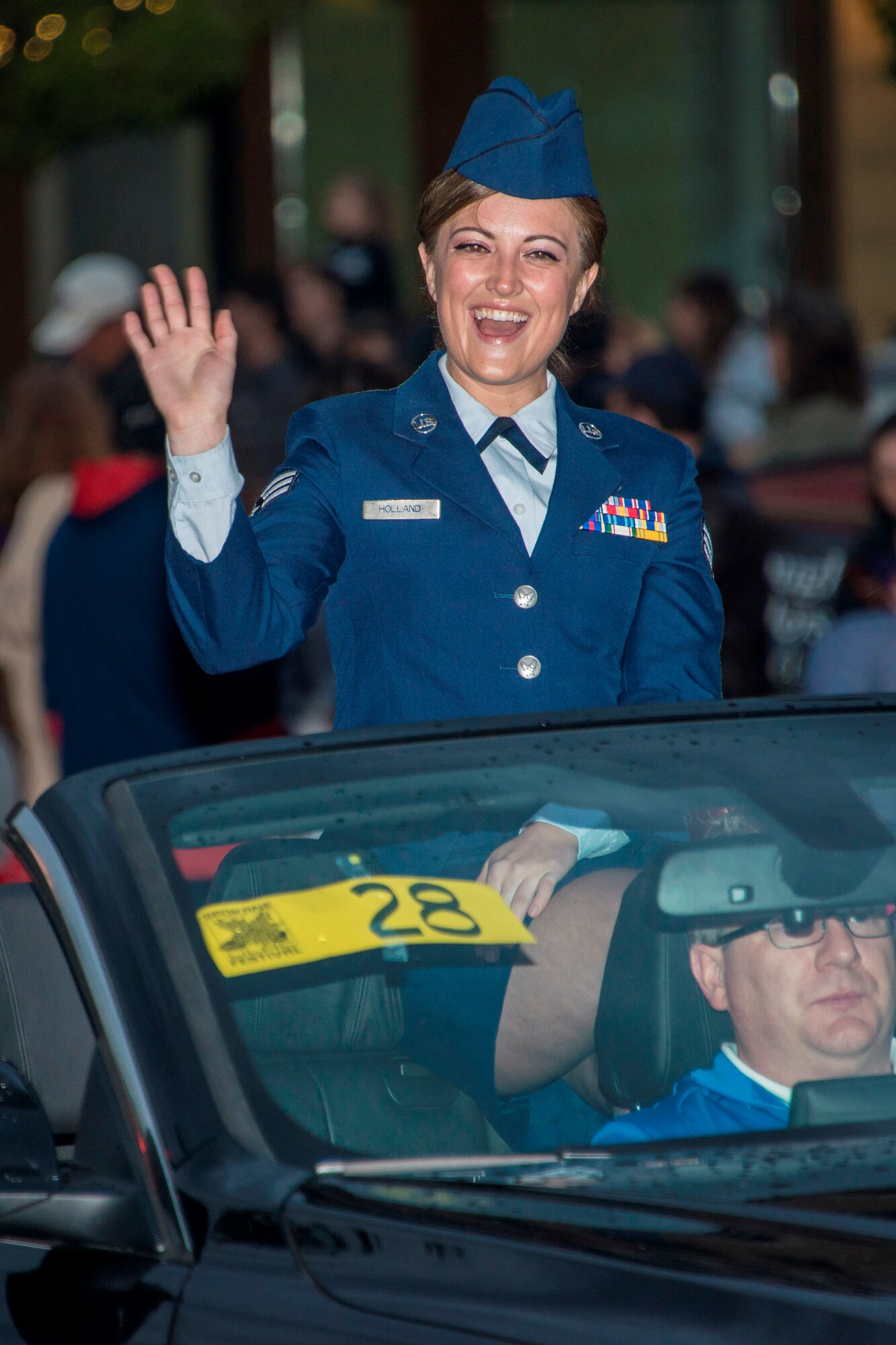 Senior Airman Nicole Holland, 141st Medical Group aerospace medical technician, interacts with crowds during the 77th Annual Spokane Lilac Festival Armed Forces Torchlight Parade May 16, 2015, in downtown Spokane, Wash. Holland was recognized as the Washington Air National Guard Armed Forces Person of the Year, May 14, 2015, at the Davenport Hotel in Spokane, Wash. The Spokane Lilac Festival recognized Spokane military personnel, Fire and Police Department employees and Royalty teachers during the 77th Annual Spokane Lilac Festival Association’s All City Civic Military Luncheon. (U.S. Air Force photo/Staff Sgt. Benjamin W. Stratton)