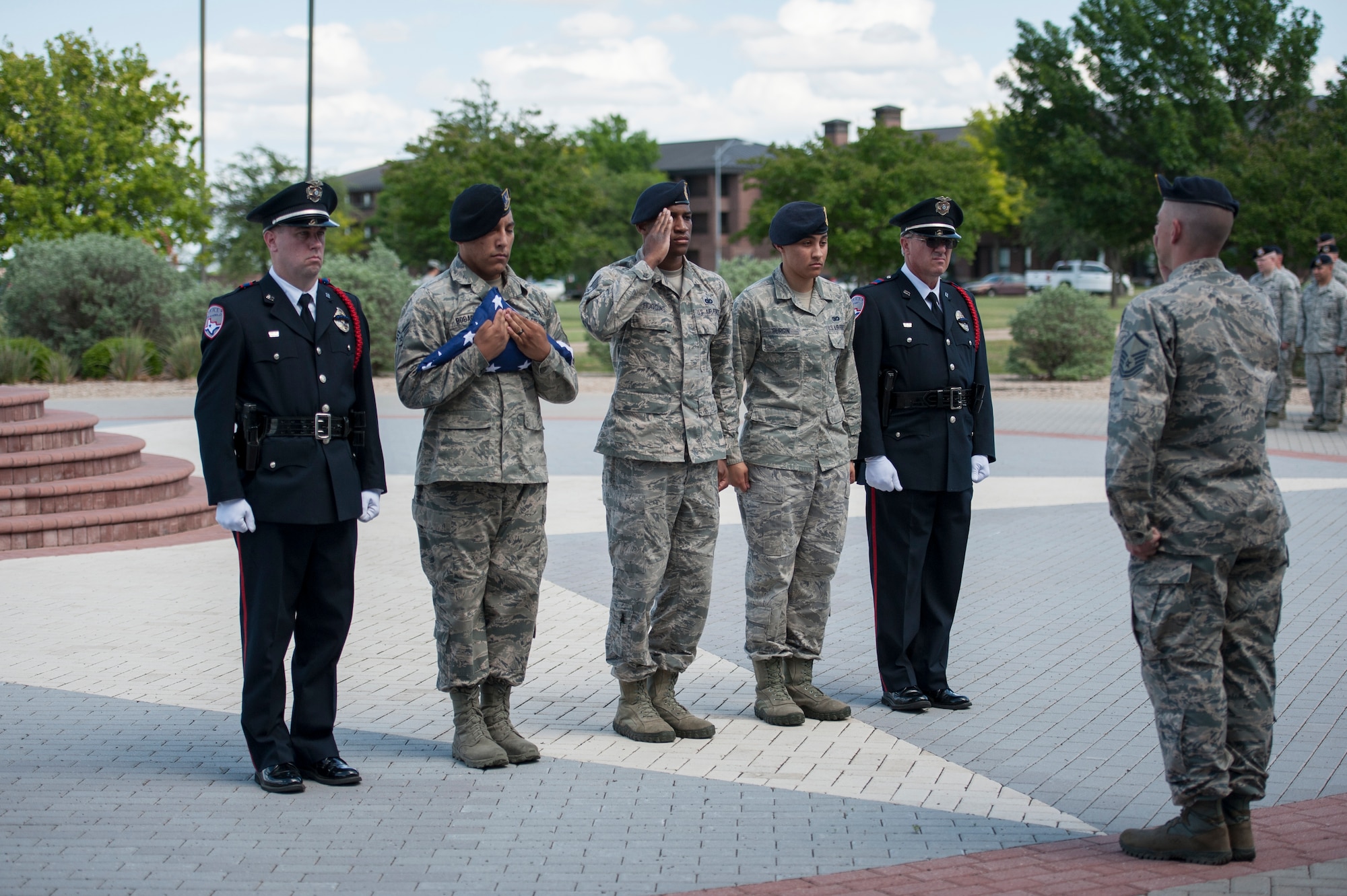 A flag detail consisting of members from the 17th Security Forces Squadron and the San Angelo Police Department ask permission to retire the American Flag during the National Police Week Retreat Ceremony in front of the Norma Brown Building on Goodfellow Air Force Base, Texas, May 15, 2015. The 17th SFS and SAPD came together and held a retreat ceremony to commemorate Peace Officers Memorial Day and National Police Week. (U.S. Air Force photo by Senior Airman Michael Smith/Released)