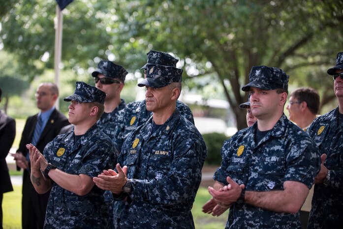 Sailors applaud guest speaker (Ret.) Col. Lawrence Lane, the first Phoenix Raven, May 15, 2015 at Joint Base Charleston, S.C., during a police week retreat ceremony. Ravens are security forces members who are extensively trained to provide security for Air Mobility Command aircraft transiting through high threat areas. The week is celebrated nationally to remember those who have been killed in the line of duty. (U.S. Air Force photo/Senior Airman Jared Trimarchi) 