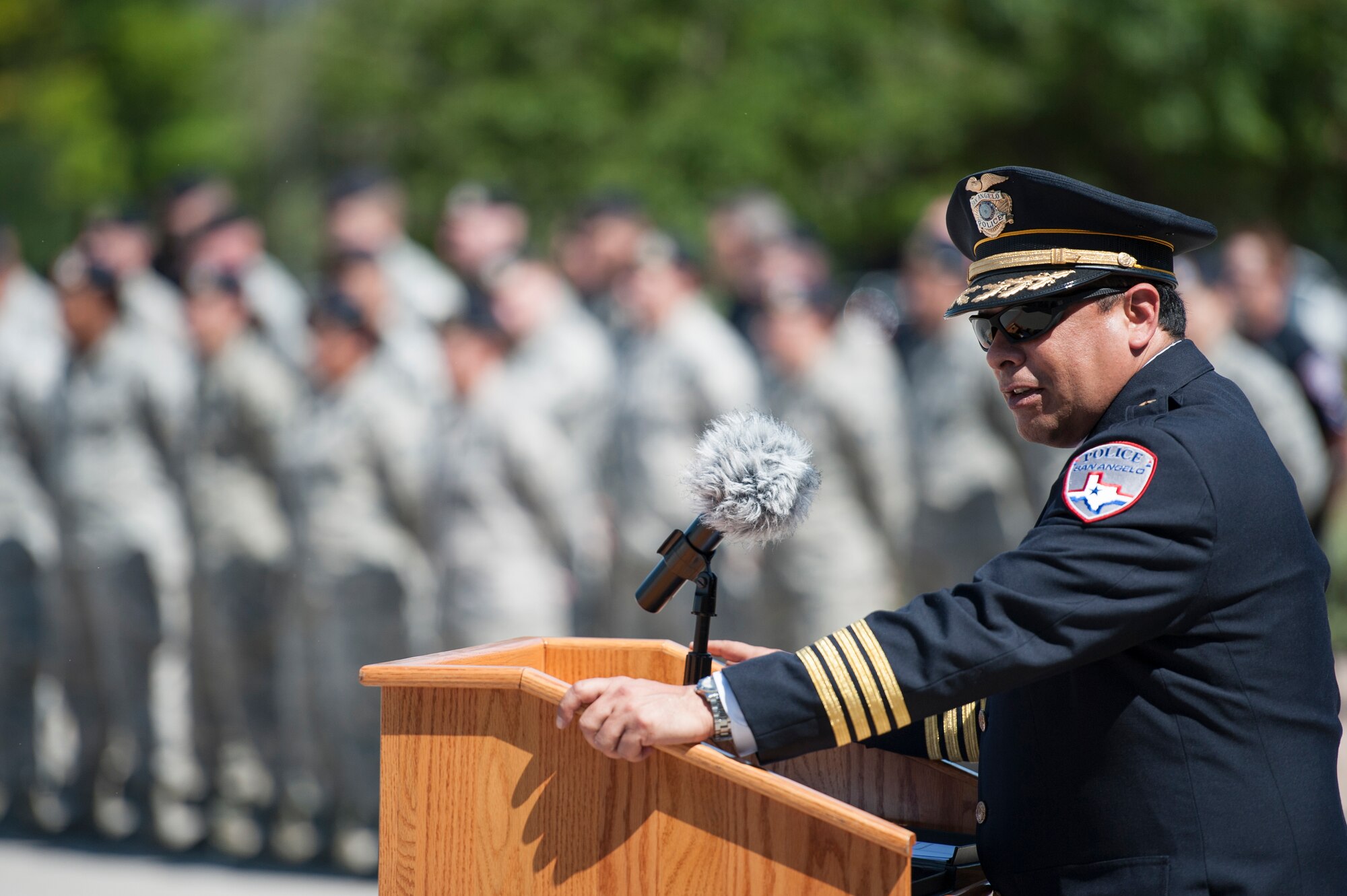 Tim R. Vasquez, San Angelo Chief of Police, gives a speech during the National Police Week Retreat Ceremony in front of the Norma Brown Building on Goodfellow Air Force Base, Texas, May 15, 2015. The 17th Security Forces Squadron and San Angelo Police Department came together and held a retreat ceremony to commemorate Peace Officers Memorial Day and National Police Week. (U.S. Air Force photo by Senior Airman Michael Smith/Released)