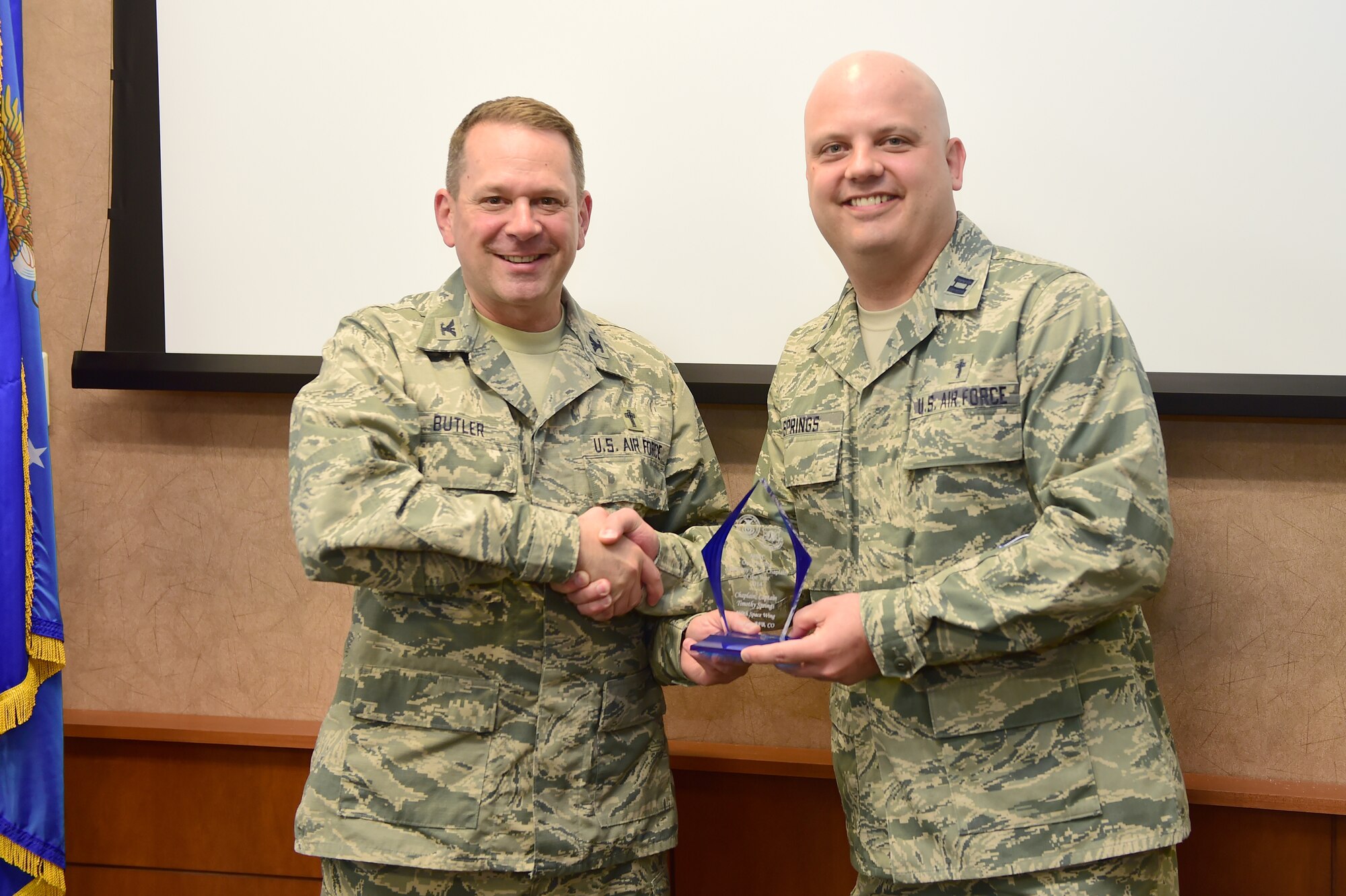 Col. Timothy A. Butler, Air Force Space Command command chaplain, left; awards Capt. Timothy D. Springs, 460th Space Wing chaplain, right; AFSPC Chaplain of the Year May 18, 2015, on Buckley Air Force Base, Colo. With a victory at the AFSPC level, Springs will now compete at the Air Force level. (U.S. Air Force photo by Airman 1st Class Luke W. Nowakowski/Released)