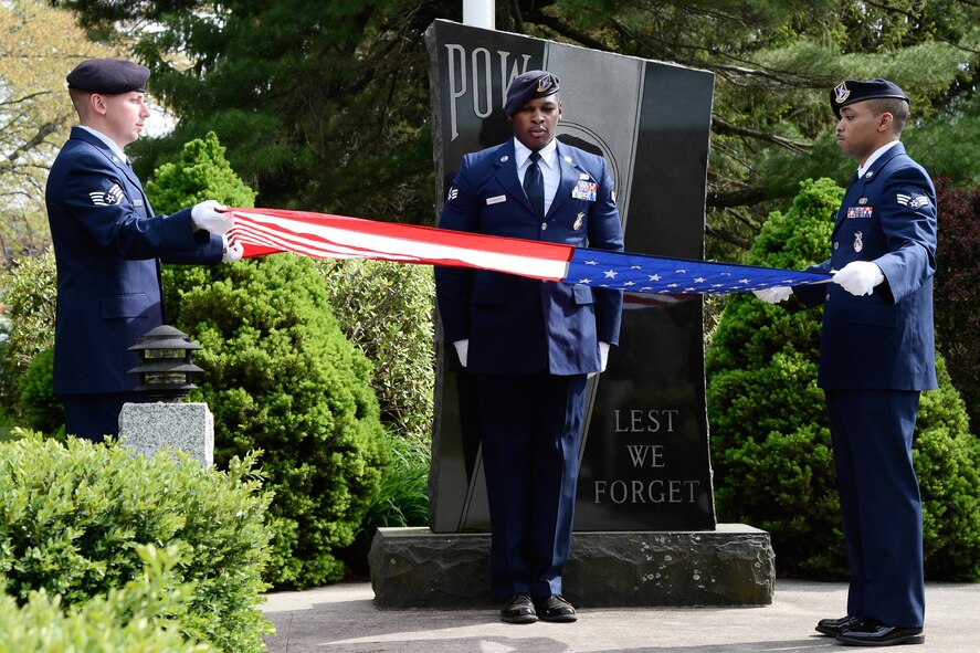 Members of the 66th Security Forces Squadron, Staff Sgt. Paul Cram (left), Senior Airman Brandon Carpenter (center) and Senior Airman Robert McQueen, fold the flag during a Police Week retreat ceremony at the POW/MIA monument on base May 15. The 66 SFS hosted events on base as part of this year's annual Police Week May 11 through 15. (U.S. Air Force photo by Mark Wyatt)
