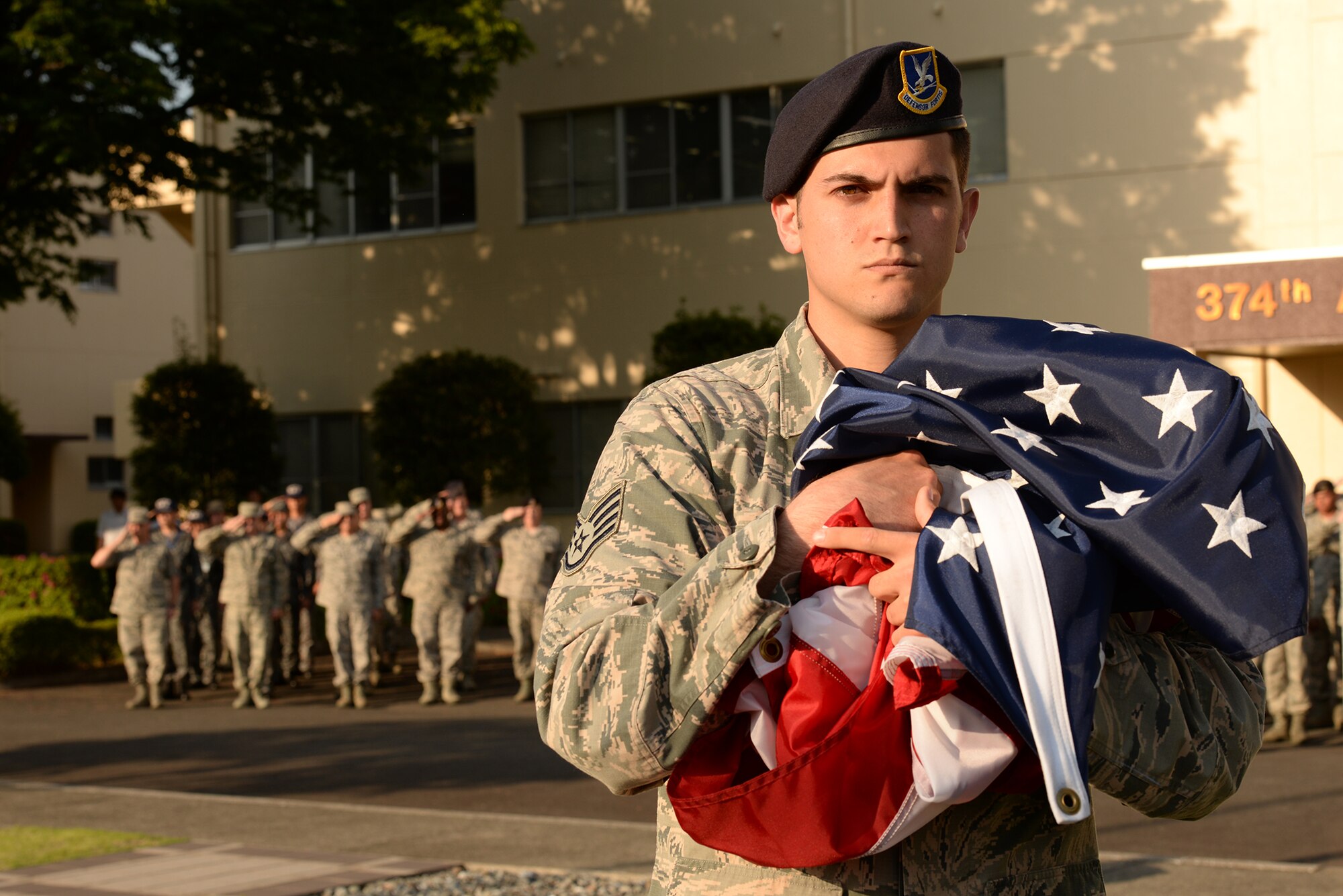Staff Sgt. Gary Bass, 374th Security Forces Squadron patrolman, holds the U.S. flag during a retreat ceremony held at Yokota Air Base, Japan, May 13, 2015. This year the 374 SFS used Police Week to pay tribute to the 10 Security Forces Airmen who have been killed in action since 9/11. (U.S. Air Force photo by Airman 1st Class Elizabeth Baker/Released)