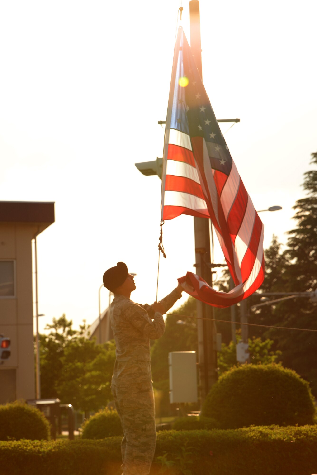 An Airman with the 374th Security Forces Squadron lowers the U.S. flag during a retreat ceremony at Yokota Air Base, Japan, May 13, 2015. The retreat was held following a memorial service in remembrance of lost defenders. (U.S. Air Force photo by Airman 1st Class Elizabeth Baker/Released)
