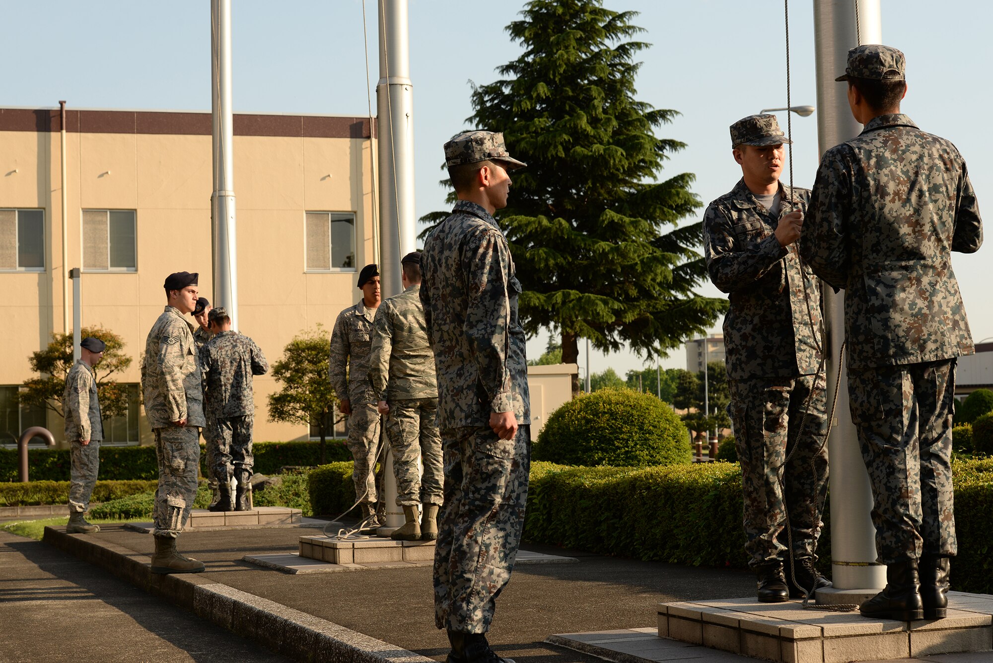 Airmen from the 374th Security Forces Squadron and their Japan Air Self-Defense Force counterparts lower the flags during a retreat ceremony, held as part of Police Week at Yokota Air Base, Japan, May 13, 2015. President John F. Kennedy signed a proclamation in 1962 designating May 15 as Peace Officers Memorial Day and the week in which that date falls as Police Week. (U.S. Air Force photo by Airman 1st Class Elizabeth Baker/Released)