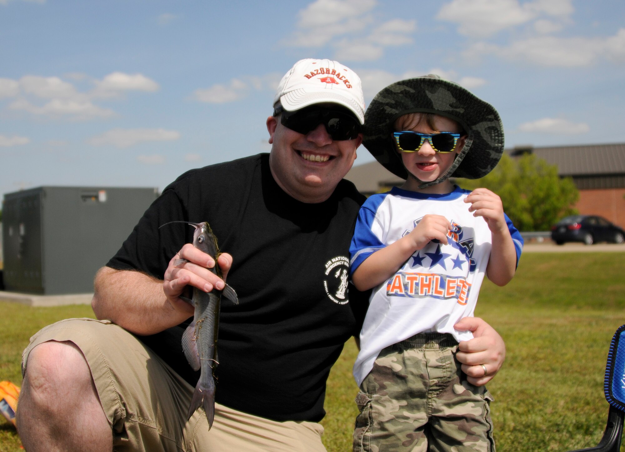Tech. Sgt. Timothy Booth, 188th Wing bioenvironmental engineer technician, holds up the fish caught by Jesse Booth during the Family Day fishing derby held May 2, 2015, at Ebbing Air National Guard Base, Fort Smith, Ark. Booth caught 6 fish for a total weight of 3.09 pounds, which equaled the most in his age group. (U.S. Air National Guard photo by Staff Sgt. Hannah Dickerson/released)