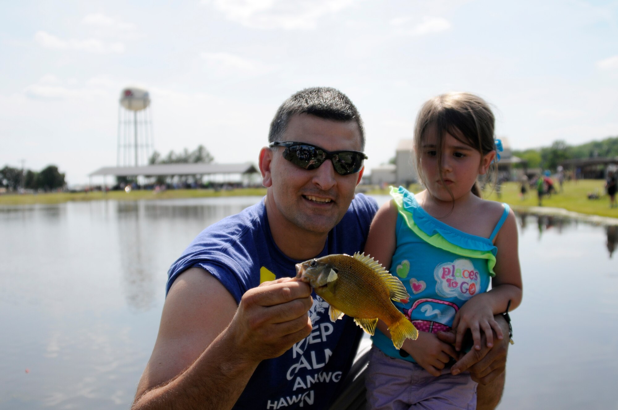 Senior Master Sgt. Josh Rich, 188th Wing emergency management superintendent, holds out the fish caught by Zoe Rich during the Family Day fishing derby held May 2, 2015, at Ebbing Air National Guard Base, Fort Smith, Ark. Rich caught one fish for a total weight of 0.04 pounds. (U.S. Air National Guard photo by Staff Sgt. Hannah Dickerson/released)