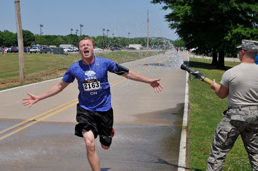 Airman 1st Class Kyle Coggins, 188th Intelligence, Surveillance and Reconnaissance Group, is hosed off during the 3rd annual Hawg Jawg held May 2, 2015, as part of a Family Day event on Ebbing Air National Guard Base, Fort Smith, Ark. Family Day brought together Guard family, friends and community members to celebrate those who support their Airmen every day. (U.S. Air National Guard photo by Staff Sgt. John Suleski/released)