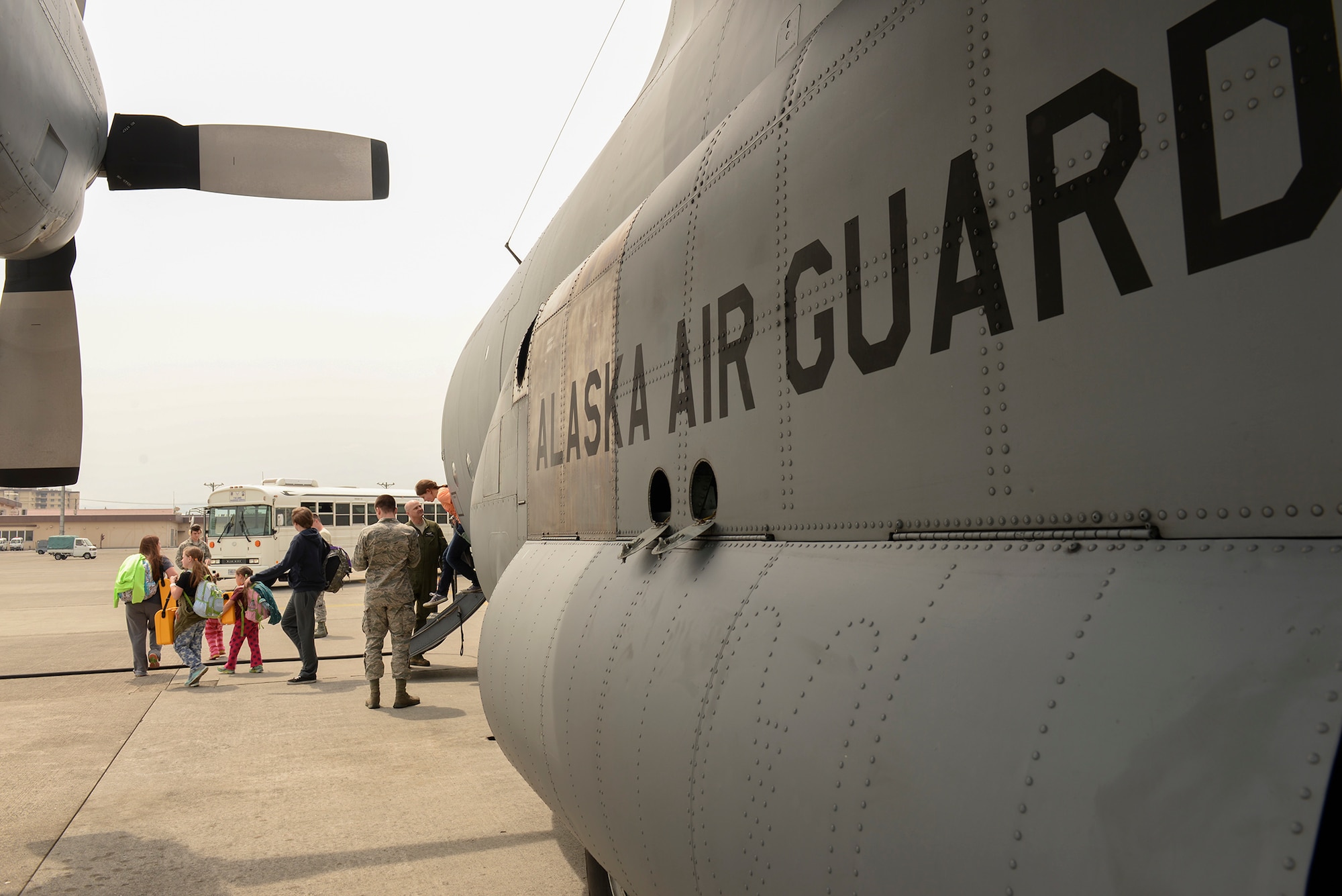 An Alaska Air National Guard C-130 Hercules unloads dependents of military members assigned to Osan Air Base, Korea, at Yokota Air Base, Japan, May 15, 2015. Capt. Jason Guinnee, a pilot with the 144th Airlift Squadron, AANG, said that the AANG is always willing and able to assist Yokota and the Pacific region in the event of a disaster. (Airman 1st Class Elizabeth Baker/Released)