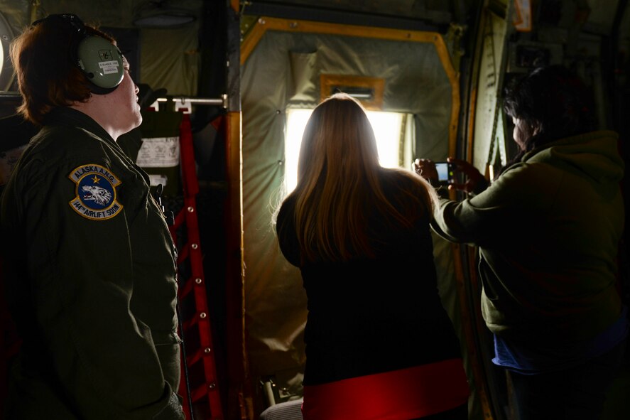 Military dependents living on Osan Air Base, Korea take photos of Mount Fuji from a C-130 Hercules during a flight from Osan to Yokota Air Base, Japan, May 15, 2015. The dependents participated in a mock evacuation after a simulated natural disaster in Korea as part of a noncombatant evacuation exercise. (Airman 1st Class Elizabeth Baker/Released)