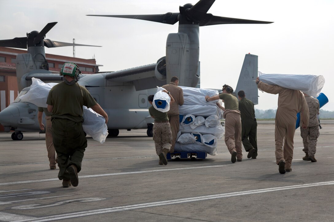 U.S. service members assigned to Joint Task Force 505 load relief supplies from Samaritan’s Purse International Relief Organization onto a U.S. Marine Corps MV-22 Osprey at Tribhuvan International Airport in Kathmandu, Nepal, May 16, 2015.