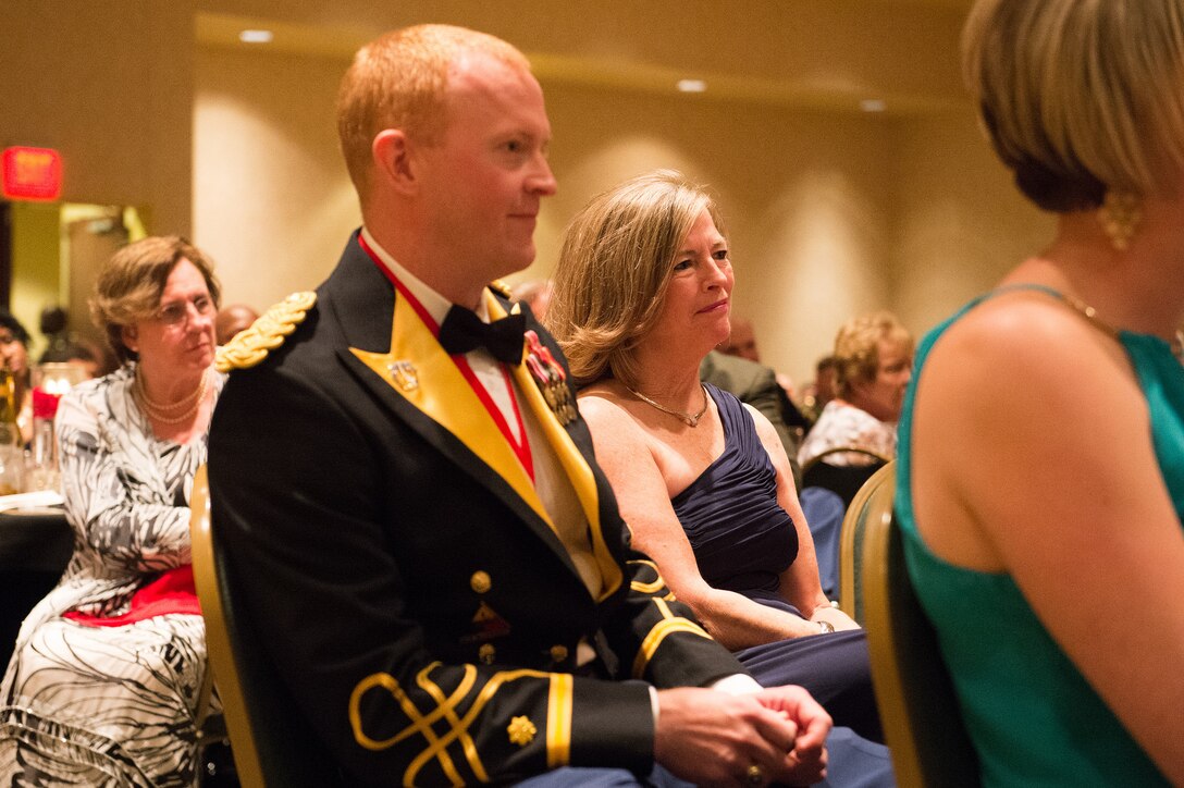 Army Maj. Chris Dempsey and his mother, Deanie Dempsey, listen as Army Gen. Martin E. Dempsey, chairman of the Joint Chiefs of Staff, gives remarks at the 2nd Armored Brigade Combat Team Ball in Junction City, Kan., May 15, 2015. 