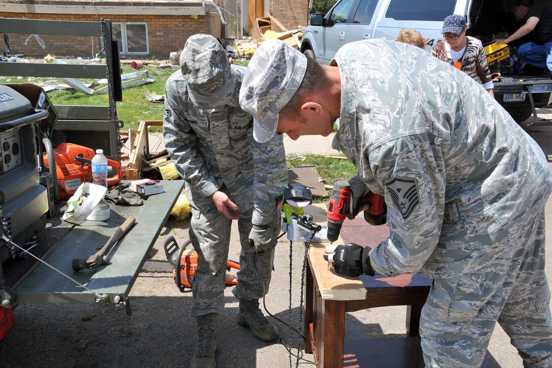 Airmen use power tools to assist residents during tornado recovery efforts in Delmont, S.D., May 12, 2015.  

