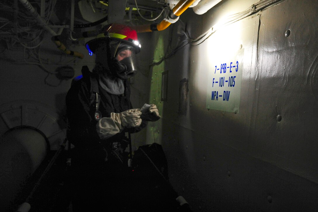 U.S. Navy Petty Officer 3rd Class Candace Thompson sets a fire boundary during a fire drill aboard the amphibious assault ship USS Boxer in the Pacific Ocean, May 7, 2015. Thompson is an boatswain’s mate.
