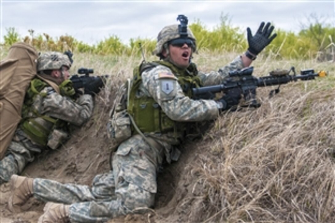 A U.S. soldier calls for members of his squad to advance during air assault training as part of exercise Maple Resolve 2015 at Camp Dundurn, Saskatchewan, Canada, May 14, 2015.  The soldiers are infantrymen assigned to the 3rd Infantry Division's 2nd Battalion, 69th Armor Regiment, 3rd Brigade. 