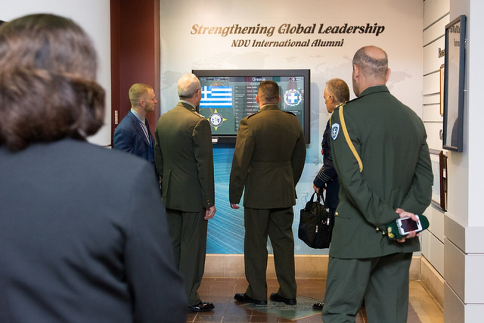 The Greek delegation views one of NDU's interactive International Alumni touch screen display in Marshall Hall.