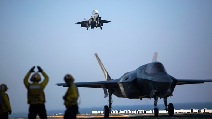A sailor aboard the USS Wasp (LHD-1) signals to the pilot of an F-35B Lightning II Joint Strike Fighter to land as it arrives for the first phase of operational testing, May 18, 2015.  The short take-off, vertical landing capabilities of the F-35B are crucial to the mission of the Marine Corps and necessary for operation aboard a Navy amphibious ship. The aircraft are stationed with Marine Fighter Attack Training Squadron 501, Marine Aircraft Group 31, 2nd Marine Aircraft Wing, Beaufort, South Carolina and Marine Fighter Attack Squadron 121, Marine Aircraft Group 13, 3rd Marine Aircraft Wing, Yuma, Arizona. (U.S. Marine Corps photo by Lance Cpl. Remington Hall/Released)