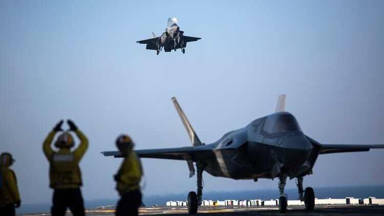 A sailor aboard the USS Wasp (LHD-1) signals to the pilot of an F-35B Lightning II Joint Strike Fighter to land as it arrives for the first phase of operational testing, May 18, 2015.  The short take-off, vertical landing capabilities of the F-35B are crucial to the mission of the Marine Corps and necessary for operation aboard a Navy amphibious ship. The aircraft are stationed with Marine Fighter Attack Training Squadron 501, Marine Aircraft Group 31, 2nd Marine Aircraft Wing, Beaufort, South Carolina and Marine Fighter Attack Squadron 121, Marine Aircraft Group 13, 3rd Marine Aircraft Wing, Yuma, Arizona. (U.S. Marine Corps photo by Lance Cpl. Remington Hall/Released)