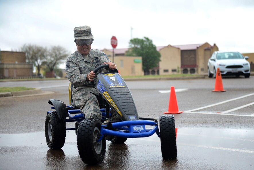 U.S. Air Force Technical Sgt. Marilyn Clayton, 27th Special Operations Security Forces Squadron Unit Training Manager, attempts the obstacles of a drunk driving simulation May 13, 2015 at Cannon Air Force Base, N.M. The simulation demonstrated the dangers of driving under the influence by having drivers don goggles that duplicate the symptoms of impairment. (U.S. Air Force Photo/Airman 1st Class Shelby Kay-Fantozzi)