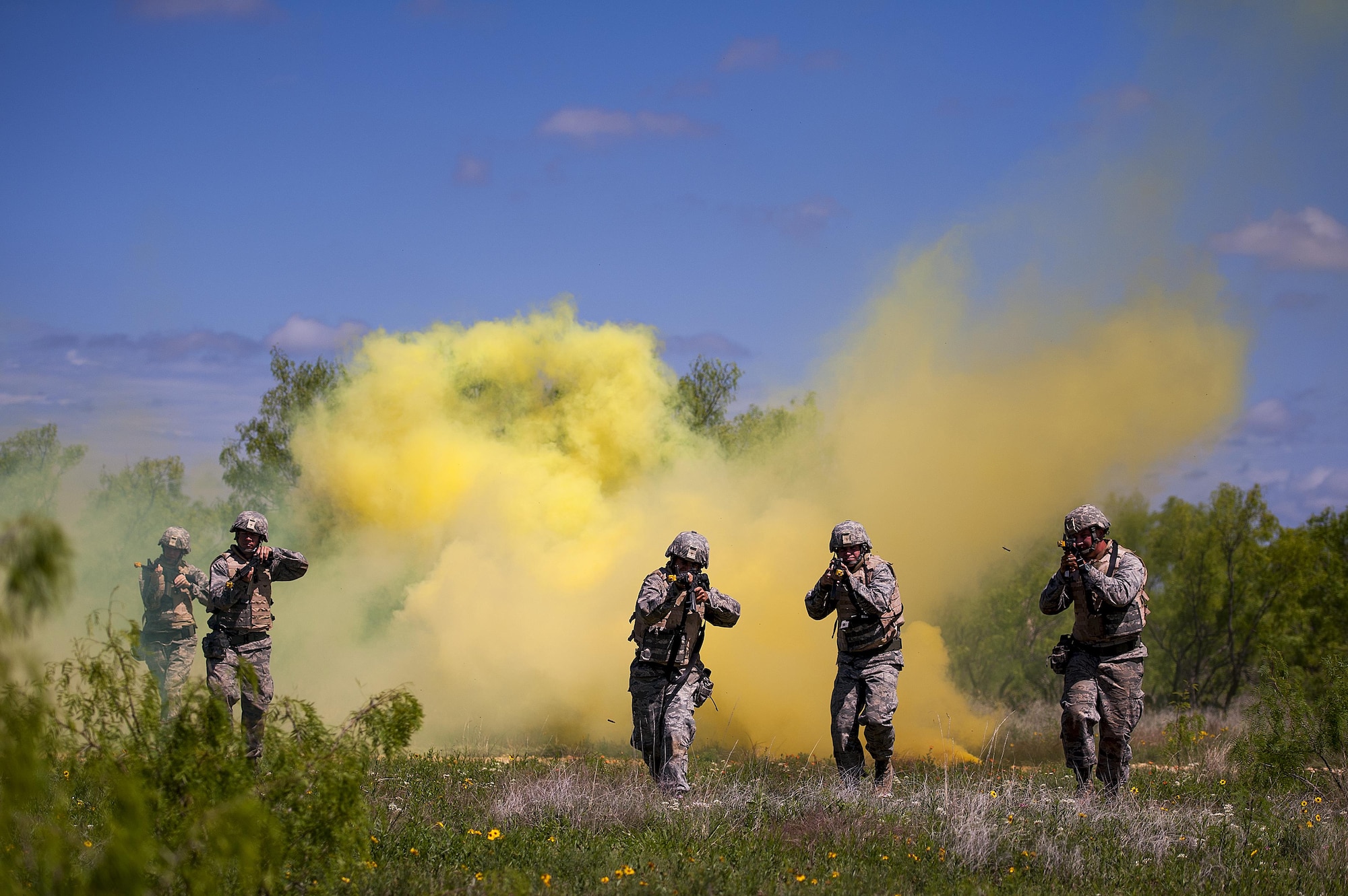 GOODFELLOW AIR FORCE BASE, Texas -- Angelo State University Air Force ROTC Detachment 847 cadets make their way through a cloud of yellow smoke during a field training exercise at a deployed simulation village near Camp Sentinel April 18. The FTX is designed to give cadets a broader understanding of what the Air Force is truly like before committing to serve. (U.S. Air Force photo/ Airman 1st Class Devin Boyer)