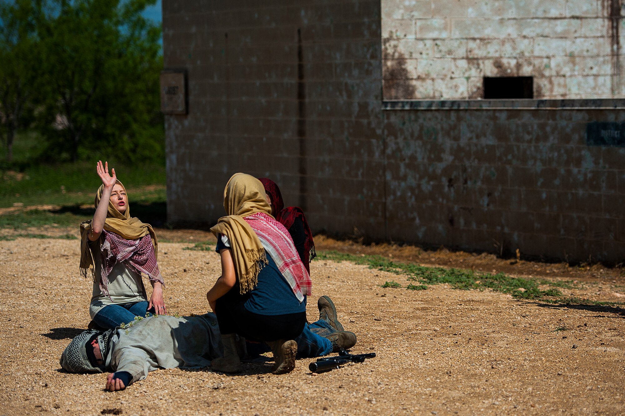 GOODFELLOW AIR FORCE BASE, Texas – 316th Training Squadron students, dressed in middle eastern attire, act out a scenario during a field training exercise at a deployed simulation village near Camp Sentinel April 18. The students pretended to mourn the death of a fellow villager by placing flowers on his body and praising to their deity. (U.S. Air Force photo/ Airman 1st Class Devin Boyer)