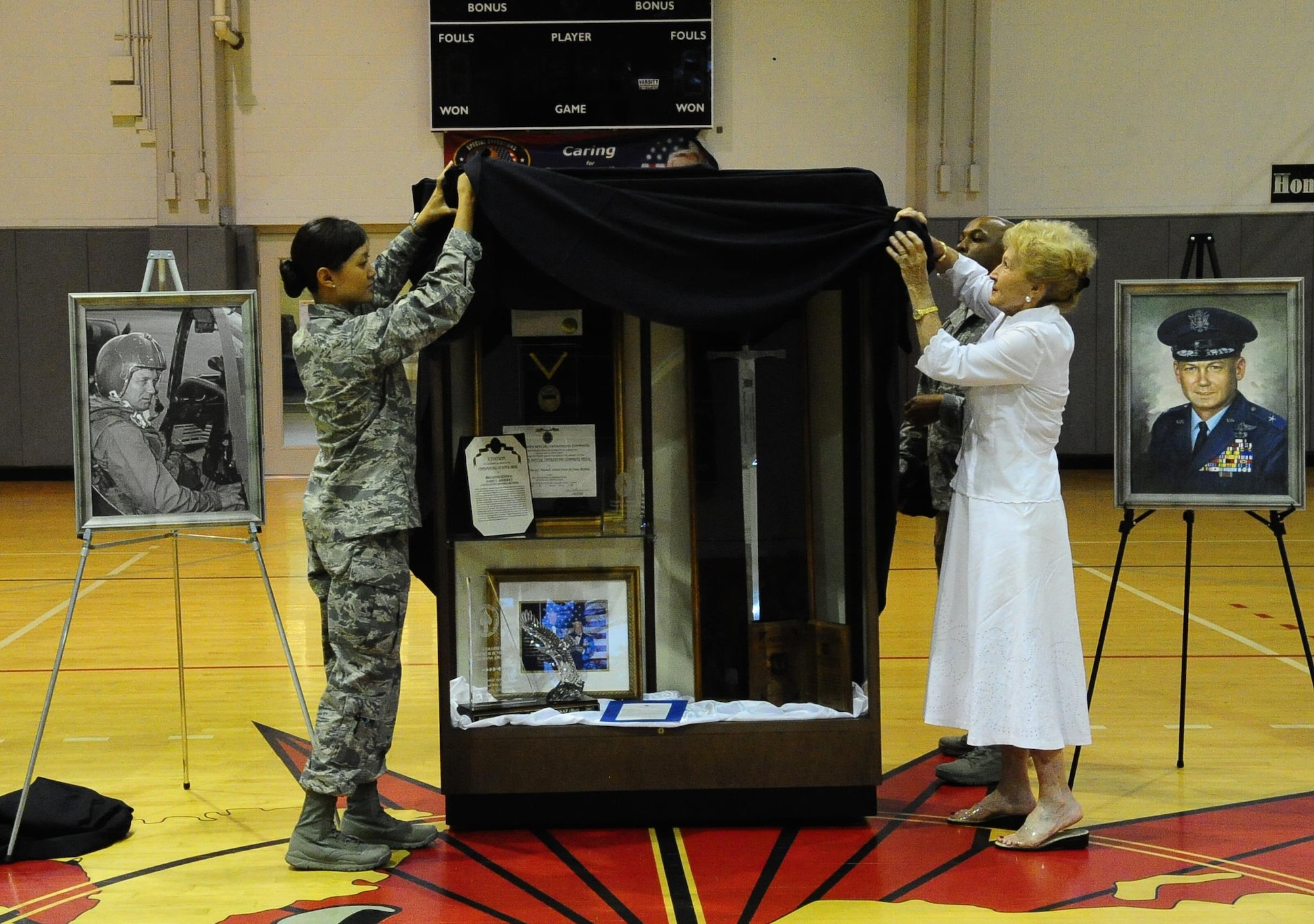 Second Lieutenant Joanne Choi, 1st Special Operations Force Support Squadron Force Management chief, and Anne Aderholt, widow of Brig. Gen.  Harry C. “Heine” Aderholt, unveil the Aderholt Display at the Aderholt Fitness Facility on Hurlburt Field, Fla., May 11, 2015. Aderholt served as the vice commander and then commander of the 1st Air Commando Wing at Hurlburt Field, a predecessor of the 1st Special Operations Wing, from March 1964 until August 1965. Hurlburt Field named the main fitness facility after General Aderholt in 2004. (U.S. Air Force photo/Airman 1st Class Andrea Posey)