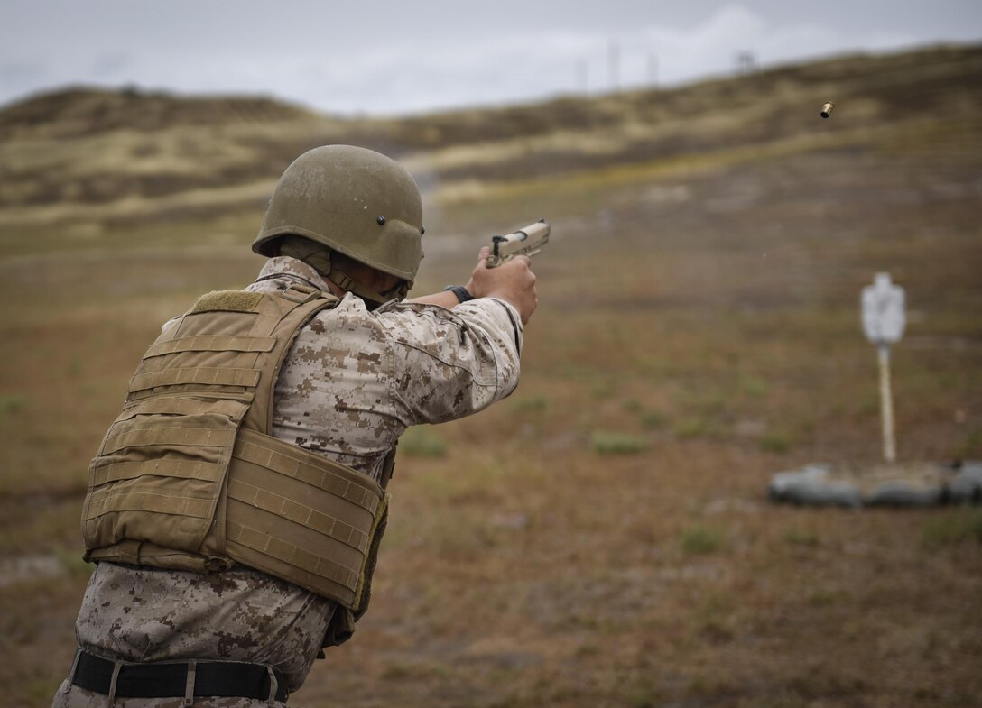 A Marine fires an M9 during obstacle 9 of the 2015 Recon Challenge aboard Camp Pendleton, California, May 15, 2015. This 30-mile gauntlet tests Marines' physical and mental strength during exercises such as finning, live fire, and pool events. Competetors carry flags of the names of fallen Recon Marines to keep their memory alive. (U.S. Marine Corps photo by Sgt. Ally Beiswanger/Released)