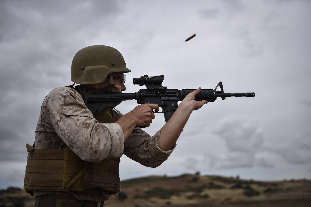 A Marine fires his M4 during obstacle 9 of the 2015 Recon Challenge aboard Camp Pendleton, California, May 15, 2015. This 30-mile gauntlet tests Marines' physical and mental strength during exercises such as finning, live fire, and pool events. Competetors carry flags of the names of fallen Recon Marines to keep their memory alive. (U.S. Marine Corps photo by Sgt. Ally Beiswanger/Released)