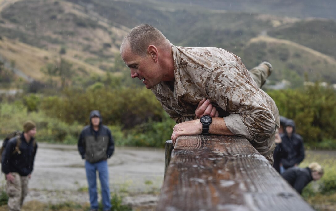 Gunnery Sgt. Zachary Holm climbs through the obstacle course during the 2015 Recon Challenge aboard Camp Pendleton, California, May 15, 2015. This 30-mile gauntlet tests Marines' physical and mental strength during exercises such as finning, live fire, and pool events. Competetors carry flags of the names of fallen Recon Marines to keep their memory alive. (U.S. Marine Corps photo by Sgt. Ally Beiswanger/Released)