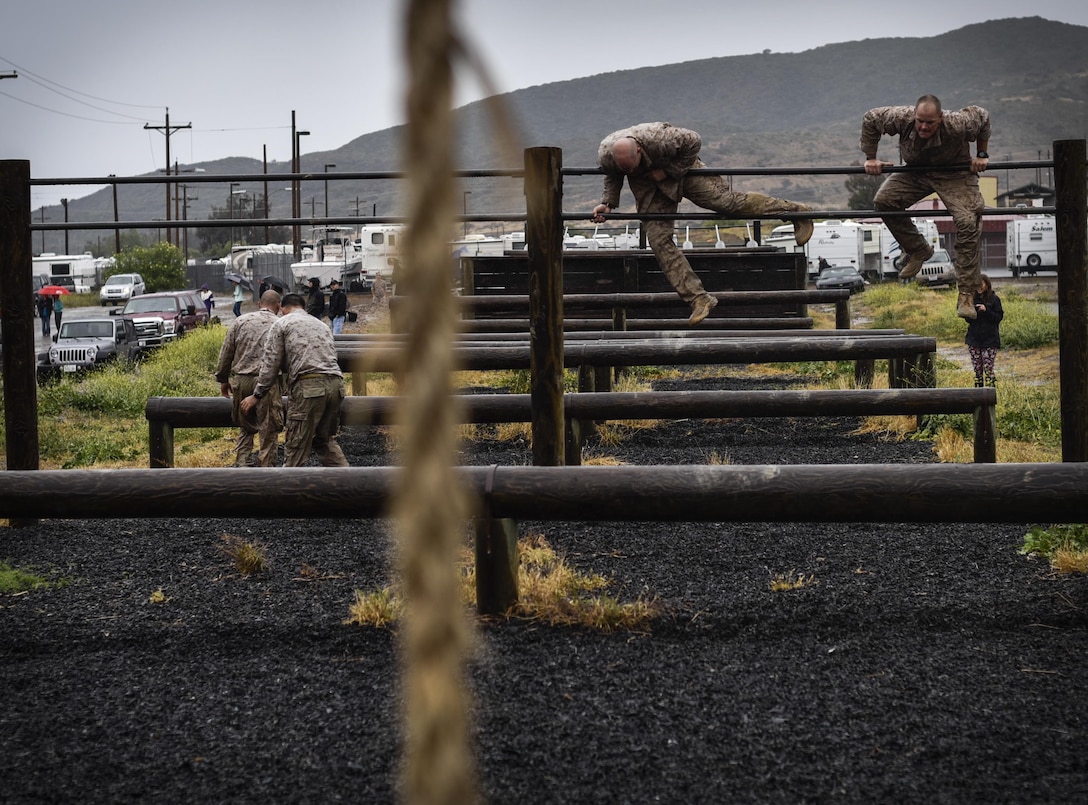 Marines climb through the obstacle course during the 2015 Recon Challenge aboard Camp Pendleton, California, May 15, 2015. This 30-mile gauntlet tests Marines' physical and mental strength during exercises such as finning, live fire, and pool events. Competetors carry flags of the names of fallen Recon Marines to keep their memory alive. (U.S. Marine Corps photo by Sgt. Ally Beiswanger/Released)