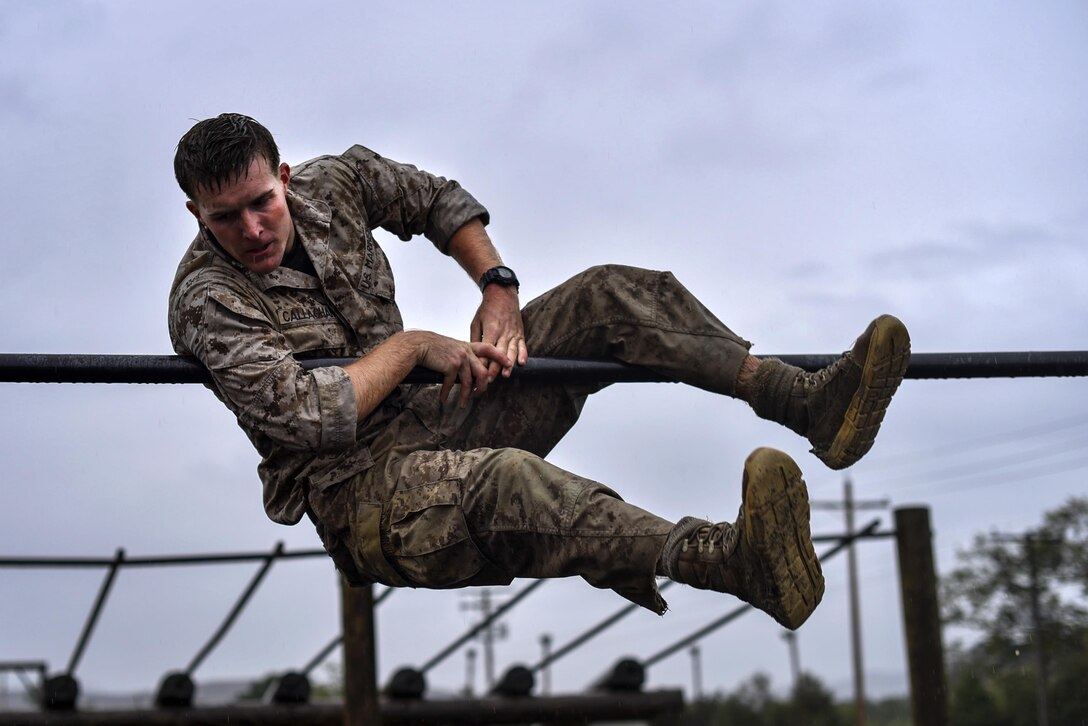 A Marine climbs through the obstacle course during the 2015 Recon Challenge aboard Camp Pendleton, California, May 15, 2015. This 30-mile gauntlet tests Marines and sailors' physical and mental strength during exercises such as finning, live fire, and pool events. Competetors carry flags of the names of fallen Recon Marines to keep their memory alive. (U.S. Marine Corps photo by Sgt. Ally Beiswanger/Released)