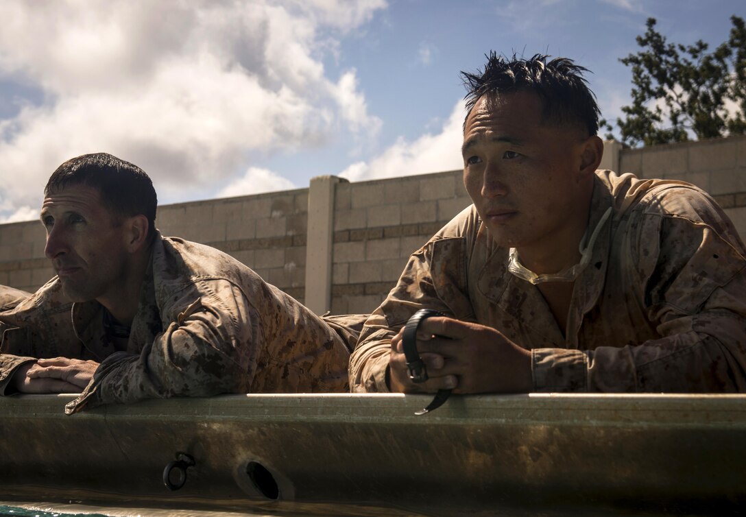 Marines time their partner as they swim laps to prepare for the 2015 Recon Challenge aboard Camp Pendleton, California. This 30-mile gauntlet tests Marines and sailors' physical and mental strength during exercises such as finning, live fire, and pool events. Competetors carry flags of the names of fallen Recon Marines to keep their memory alive. (U.S. Marine Corps photo by Sgt. Ally Beiswanger/Released)