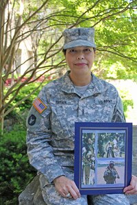 Chief Warrant Officer 4 Lisa Bryan of the Kansas Army National Guard holds a photo of her late cousin Marine Corps Lance Cpl. Hatak-Yuka-Keya Martin Yearby who was killed in action May 14, 2006, while conducting combat operations in Anbar province, Iraq. Bryan escorted his body from the Air Mortuary at Dover Air Force Base, Del. to Yearby’s hometown in Overbrook, Oklahoma.