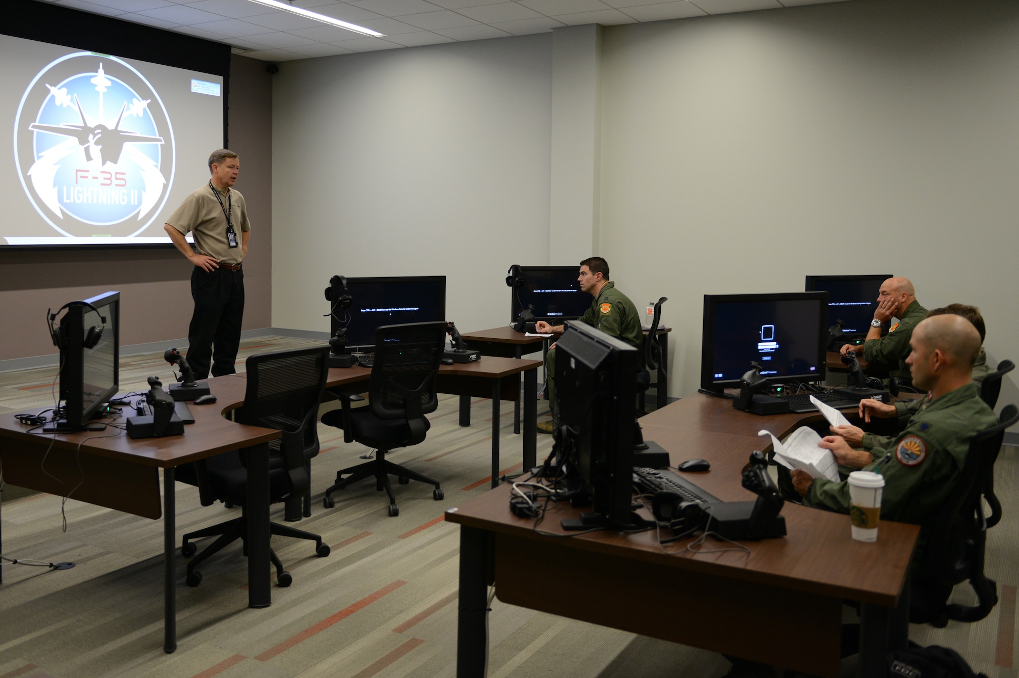 Travis Byrom, a Lockheed Martin instructor pilot, briefs students in the first F-35 Lightning II training class May 5, 2015, at Luke Air Force Base, Ariz. Upon completion of training, the students will assume the role of instructor to teach future classes of F-35 students. (U.S. Air Force photo/Senior Airman James Hensley)