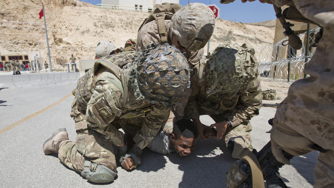 U.S. Marines with India Company, 3rd Battalion, 7th Marine Regiment, Special Purpose Marine Air-Ground Task Force-Crisis Response, Central Command, and British airmen with 51st Squadron, Royal Air Force Regiment, subdue an aggressive role player during a non-combatant evacuation operation as part of Exercise Eager Lion at the King Abdullah Special Operations Training Center in Amman, Jordan, May 15, 2015. Eager Lion is a recurring, multinational exercise designed to strengthen military-to-military relationships, increase interoperability between partner nations, and enhance regional security and stability.