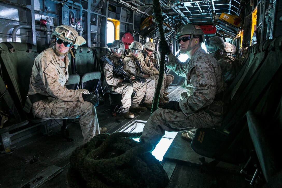 U.S. Marines with the 15th Marine Expeditionary Unit’s Maritime Raid Force security element prepare to fast rope out of a CH-53E Super Stallion aboard Marine Corps Base Hawaii, May 12, 2015. Fast roping is an essential skill for the security element because it allows them to rapidly insert into an objective while avoiding potential ground obstacles or enemy forces. (U.S. Marine Corps photo by Cpl. Anna Albrecht/Released)