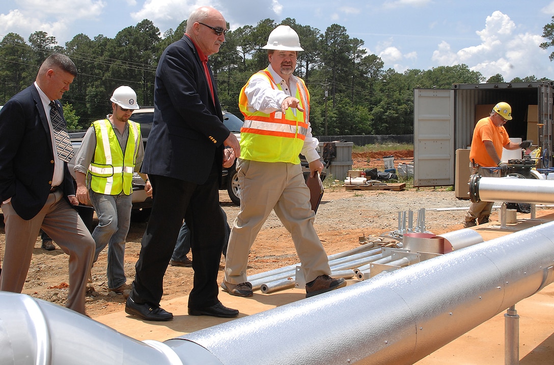 Assistant Secretary of the Navy, the Honorable Dennis V. McGinn (center), Energy, Installations and Environment, tours the ground source heat pump project area with Charles W. Hammock Jr., vice president, Andrews, Hammock and Powell, INC., during his visit to Marine Corps Logistics Base Albany, Georgia, May 19. The project is a borehole thermal energy storage system which is a state-of-the-art ground source heat pump system for heating and cooling Building 3700, the Marine Corps Logistics Command headquarters building.  