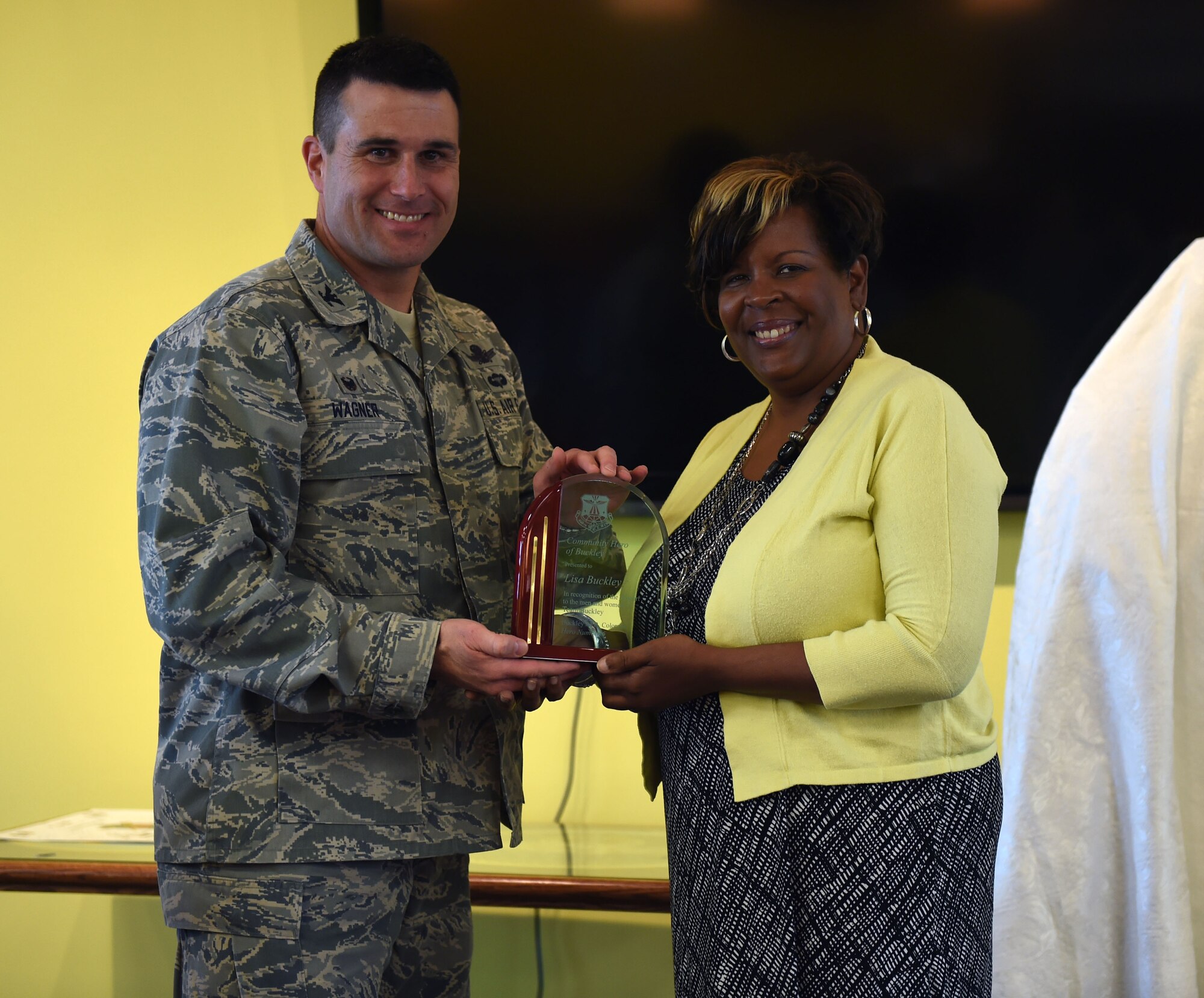 Lisa R. Buckley, American Automation Building Solutions Inc. chief of operations, is presented the Community Hero of Buckley award by Col. John Wagner, 460th Space Wing commander, May 14, 2015, at the Panther Den on Buckley Air Force Base, Colo. Every year, Buckley AFB recognizes one individual from the local community for their efforts made toward supporting Team Buckley by presenting them the Community Hero of Buckley award. (U.S. Air Force Photo/Airman 1st Class Emily E. Amyotte)