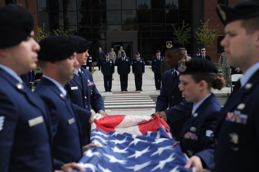 Team Fairchild leadership looks on as the 92nd Security Forces Squadron Airmen fold the American Flag during the retreat ceremony May 15, 2015, at Fairchild Air Force Base, Wash. Established by a joint resolution of Congress in 1962, National Police Week pays special recognition to those law enforcement officers who have lost their lives in the line of duty for the safety and protection of others. (U.S. Air Force photo/Airman 1st Class Nicolo J. Daniello)