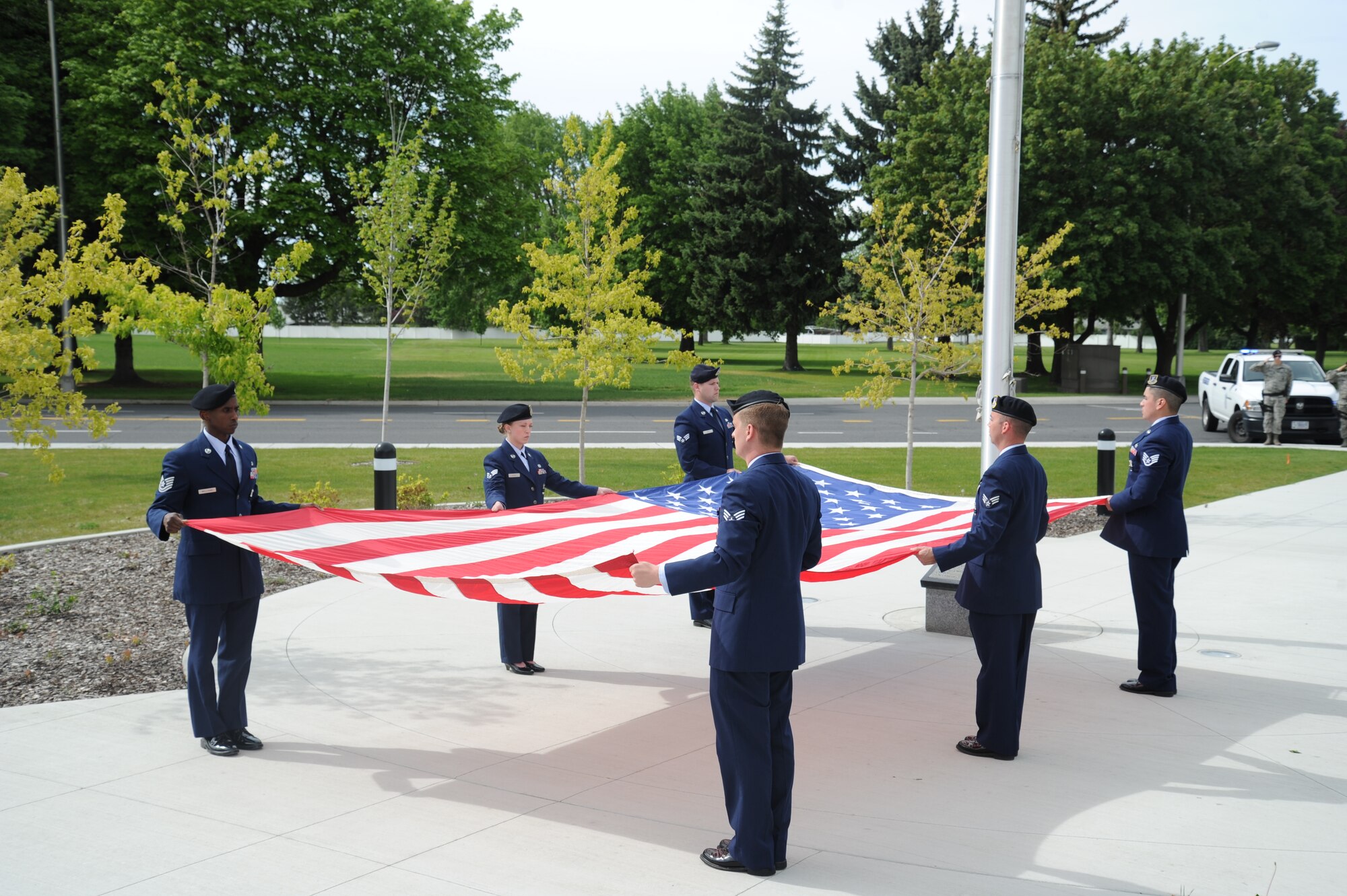Members from the 92nd Security Forces Squadron hold the American Flag during the retreat ceremony May 15, 2015, at Fairchild Air Force Base, Wash. Established by a joint resolution of Congress in 1962, National Police Week pays special recognition to those law enforcement officers who have lost their lives in the line of duty for the safety and protection of others. (U.S. Air Force photo/Airman 1st Class Nicolo J. Daniello)