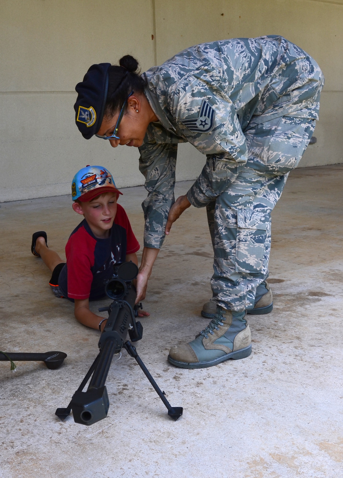 Staff Sgt. Yerida Vazquez, 36th Security Forces Squadron combat arms instructor introduces a young base resident to a .50-caliber rifle, May 12, 2015, at Andersen Air Force Base, Guam. The 36th SFS Airmen participated in skills display, which included multiple police weapons and a Humvee at the Exchange at Andersen AFB, in recognition of National Police Week. (U.S. Air Force photo by Airman 1st Class Alexa Ann Henderson/Released)