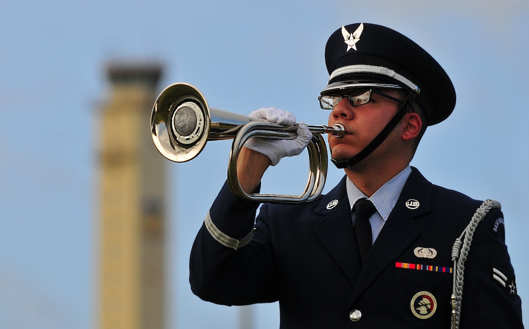Airman 1st Class Carlos Vazquez, a 36th Communications Squadron cybertransport technician, sounds the Taps bugle call during a Police Week retreat ceremony May 13, 2015, at Andersen Air Force Base, Guam. The ceremony honored security forces members and military working dogs who have lost their lives in the line of duty. (U.S. Air Force photo by Senior Airman Alexander W. Riedel/Released) 