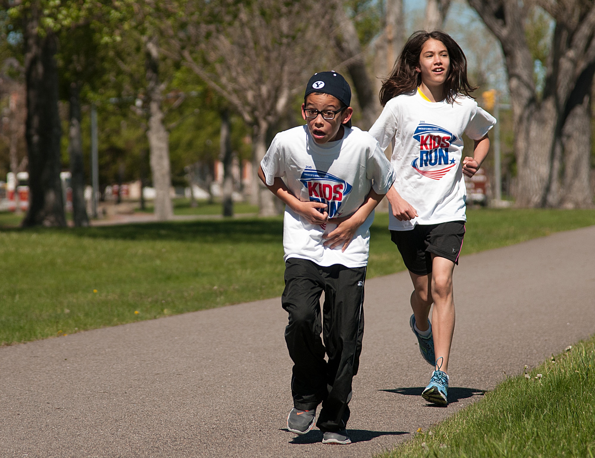 Everett Taylor, 10, pushes himself to stay ahead of his sister, Abigail, 11, during the America’s Kids Run race on the track around the Argonne Parade Field on F.E. Warren Air Force Base, Wyo., May 16, 2015. Ultimately, Abigail took first place in the 10 to 11 age group during the race.  (U.S. Air Force photo by Senior Airman Jason Wiese)